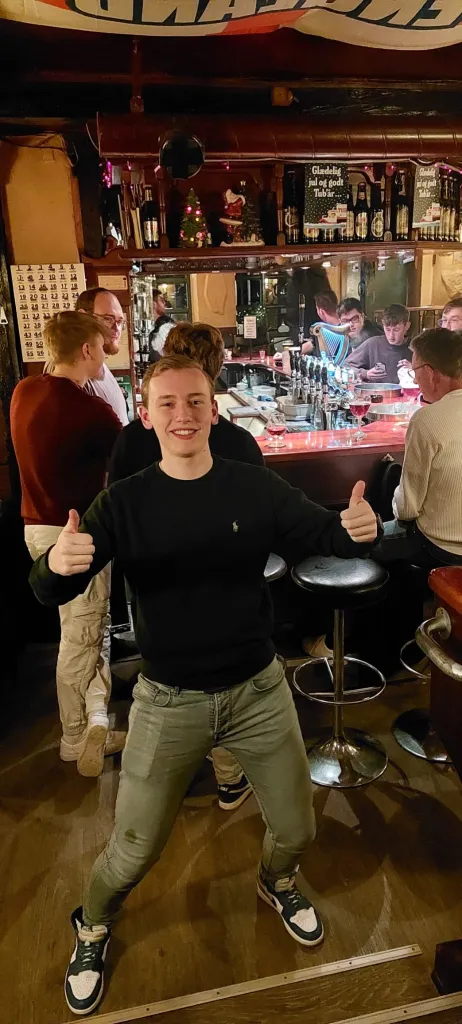 Student giving thumbs up in a festive pub