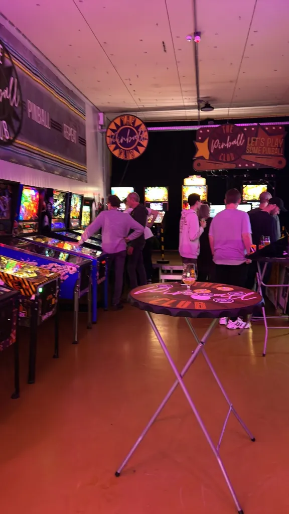 The Pinball Club arcade with neon lights and players