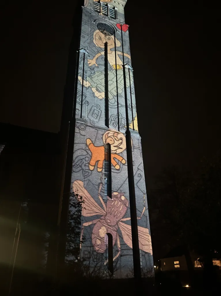 Clock tower with cartoon light projection at night